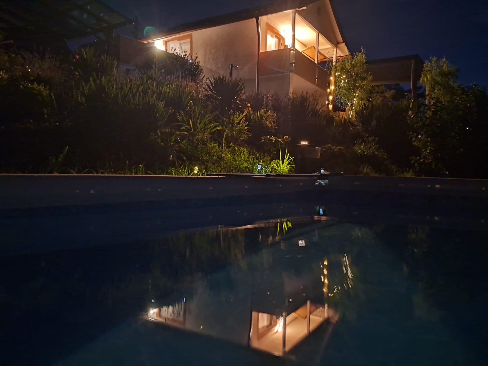 Ferienhaus und Pool bei Nacht