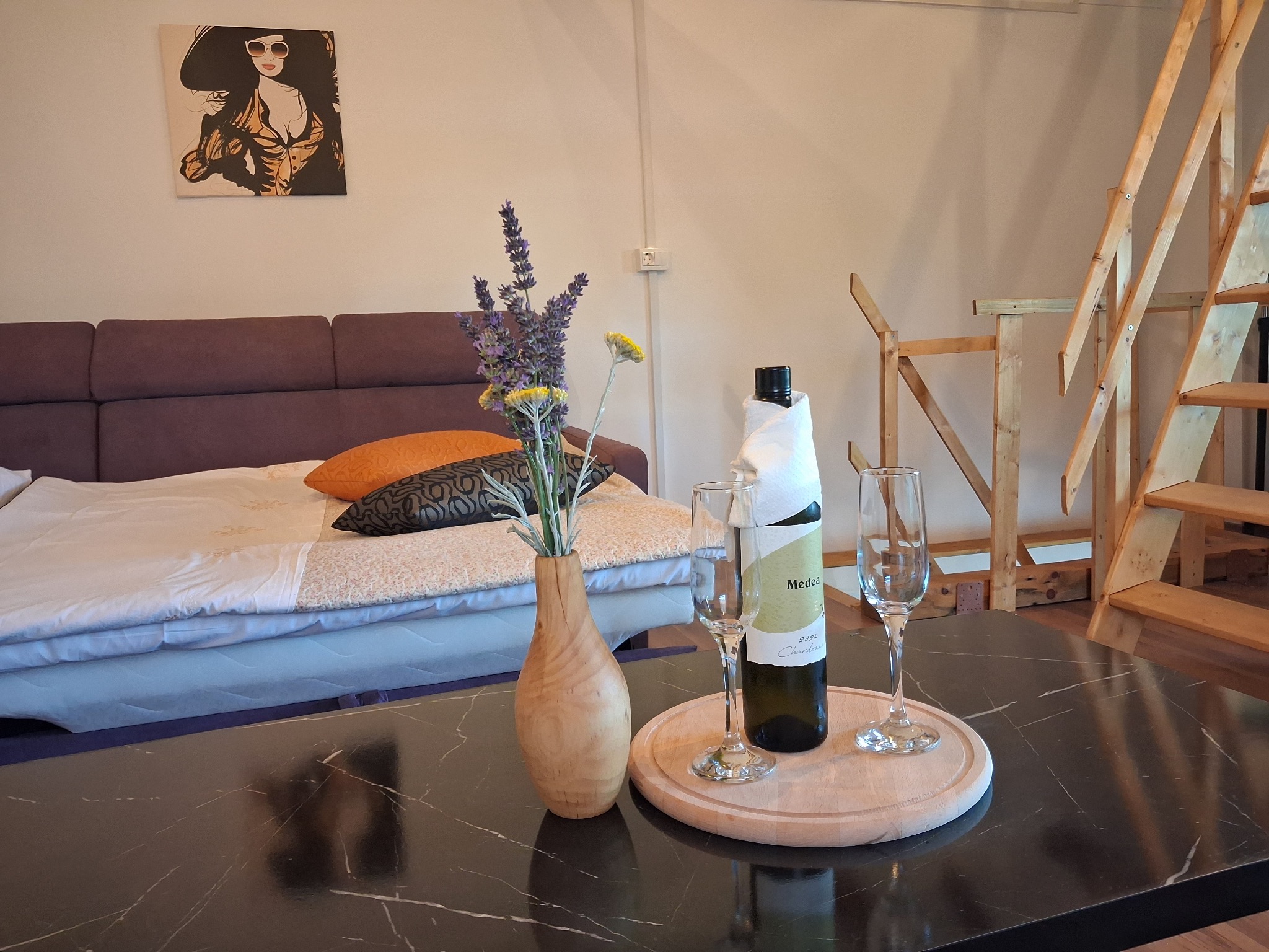 Schlafbereich mit Doppel-Schlafcouch und Holztreppe